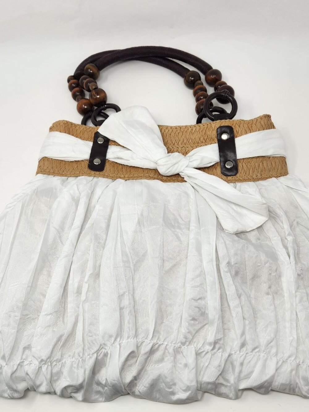 New white cloth handbag with tan straw band and brown bead handle